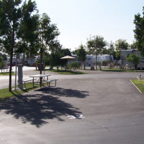 An image showing the spacious full-service RV sites, nestled among the lush orange groves at Orangeland RV Park in Orange, CA.